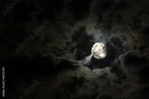 Full moon and eerie white clouds against a black night sky