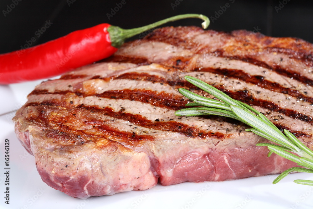 Juicy beef steak with red chili pepper and rosemary