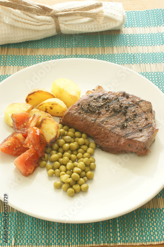 grilled pepper steak with roasted potato and pea
