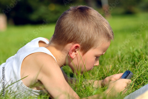 kid with mobile phone on a summer meadow