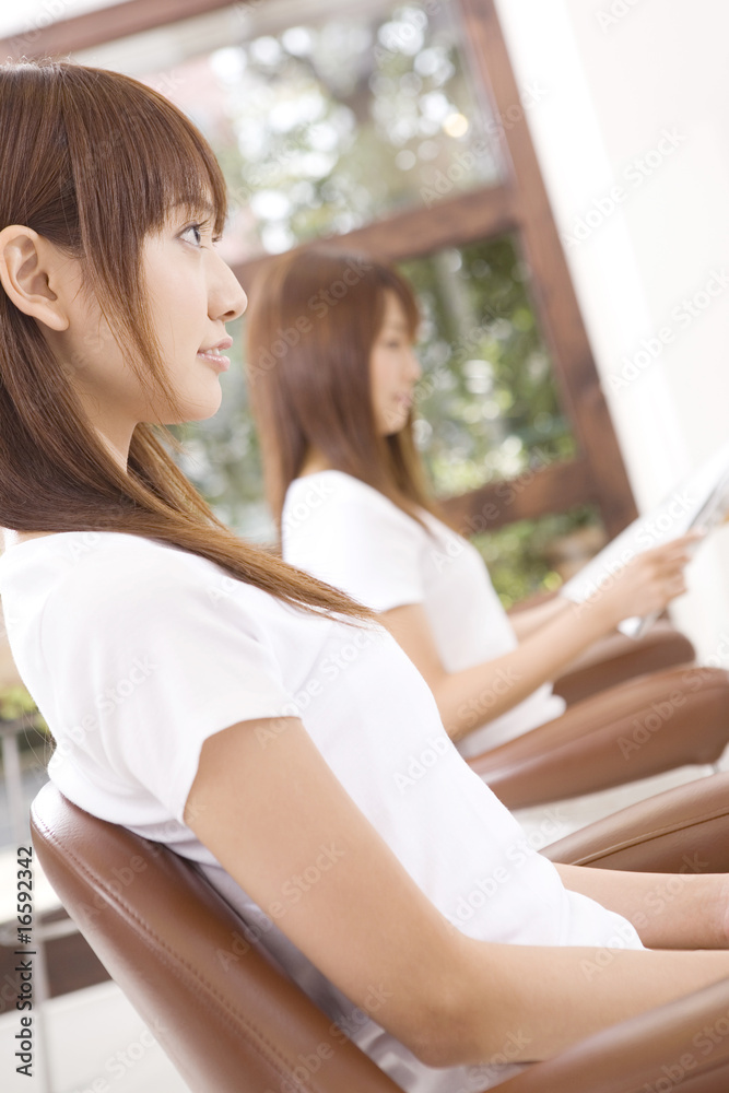 Naklejka premium ヘアサロンでカット台に座った女性