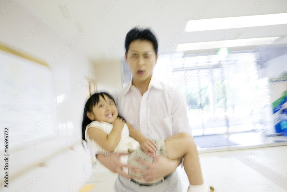 © Paylessimages - 娘を抱えて病院に連れてきた父親