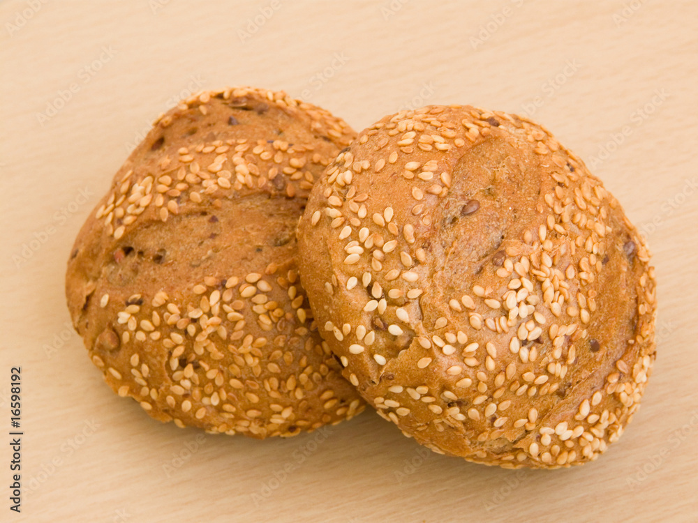 Sesame buns on the wooden background. Shallow DOF. Sesame buns on the wooden background. Shallow DOF.