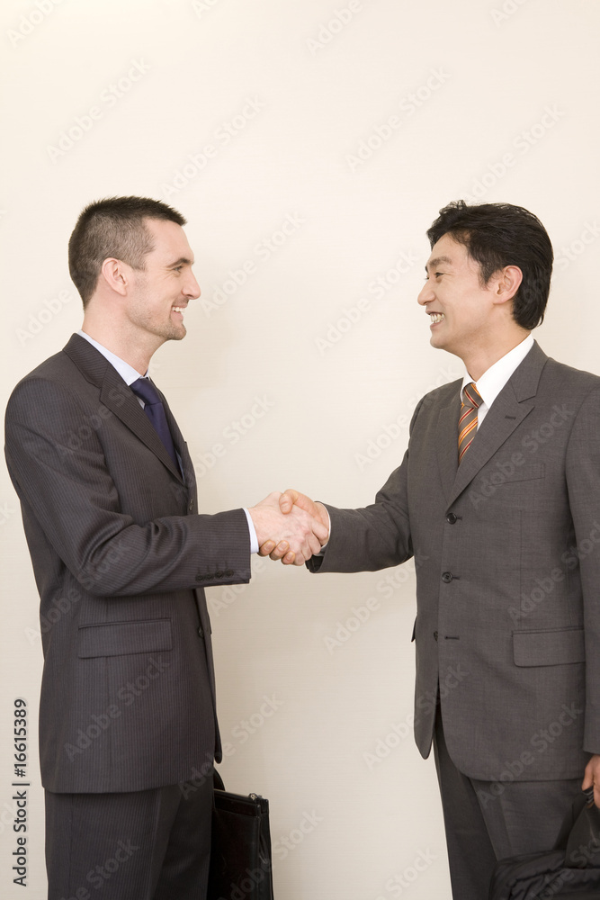 握手する日本人ビジネスマンとアメリカ人ビジネスマン 握手する日本人ビジネスマンとアメリカ人ビジネスマン