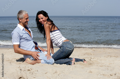Happy middle aged couple having fun on the beach © studiovespa