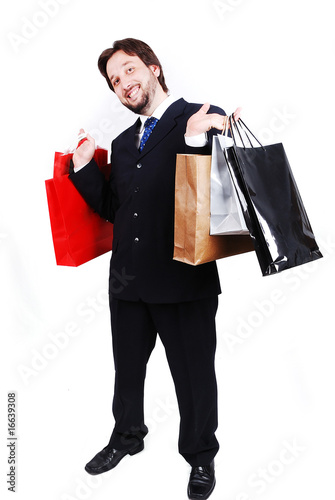 Young attractive man wearing suit and holding shopping bags