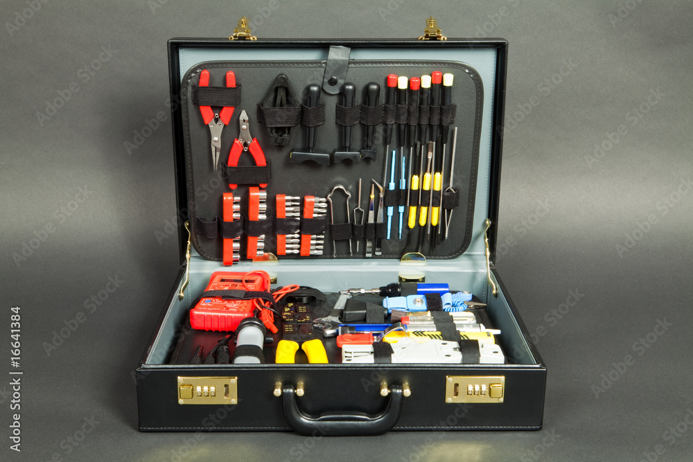 Leather suitcase with tools against a dark background Leather suitcase with tools against a dark background
