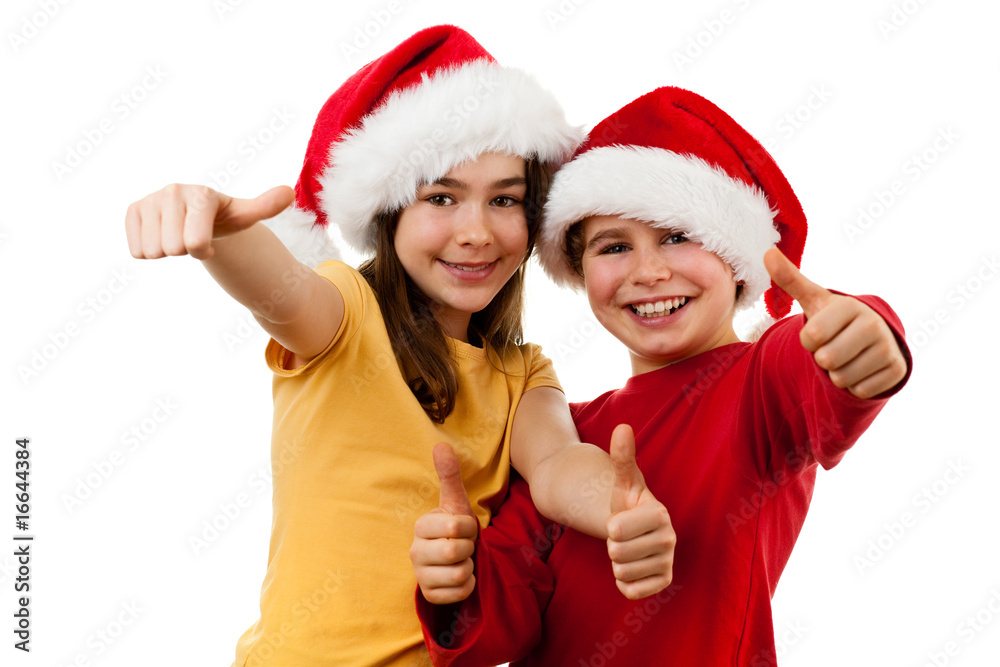 Kids wearing Santa Claus hats showing OK sign , isolated Kids wearing Santa Claus hats showing OK sign , isolated