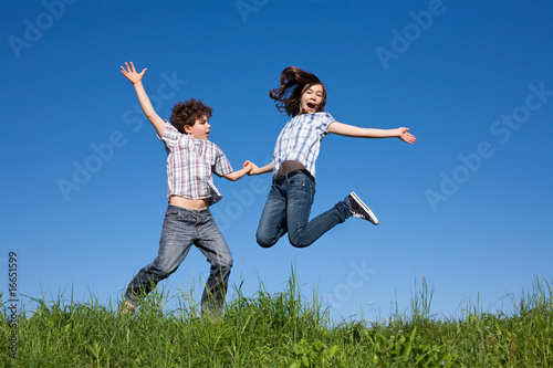 Kids running  jumping on green meadow