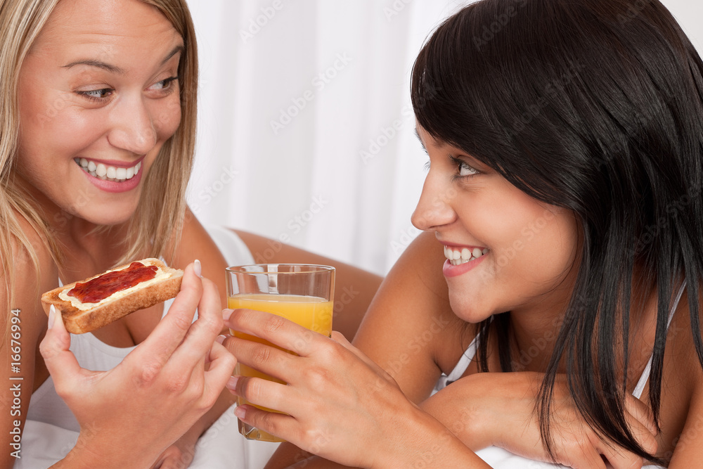 Blond woman and brunette having breakfast Blond woman and brunette having breakfast