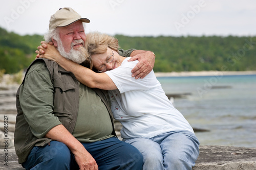 Senior couple sitting at shores edge