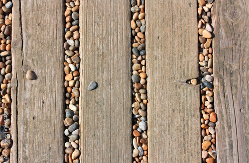 Stones in deckings gaps on beach photo