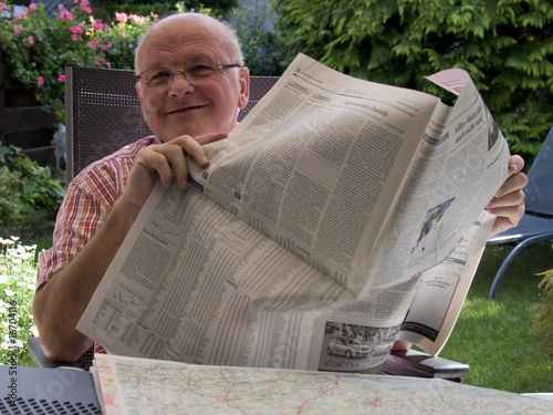 Älterer Mann entspannt beim Zeitung lesen photo