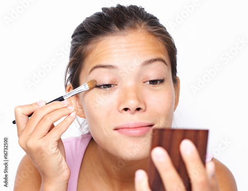 Mixed asian   caucasian woman putting makeup