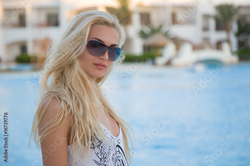 Caucasian girl on a resort pool background