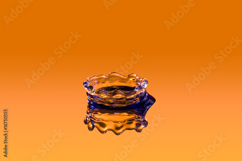 close up of a drop of water on orange backdrop