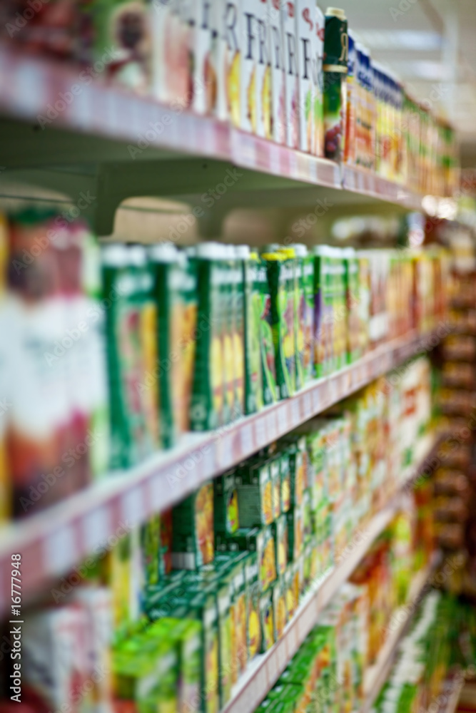 Shelves with juices in a supermarket. Blur