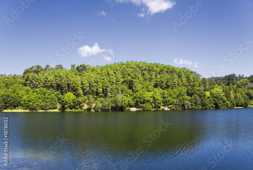 Beautiful landscape with lake in forest and clouds