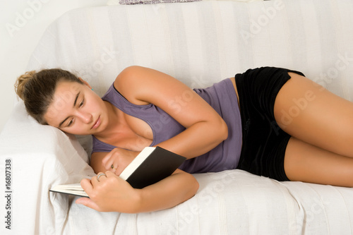 Woman  reading a book on the couch photo