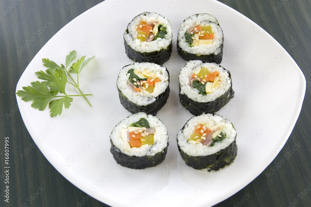 Six pieces of Korean sushi and a parsley leaf. Six pieces of Korean sushi and a parsley leaf.