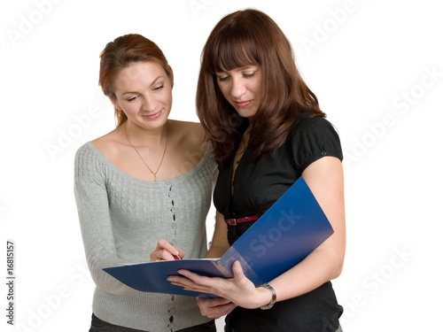 Two young women get acquainted oneself with the document.