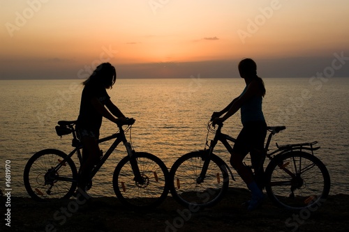 Couple with bikes watching sunset.