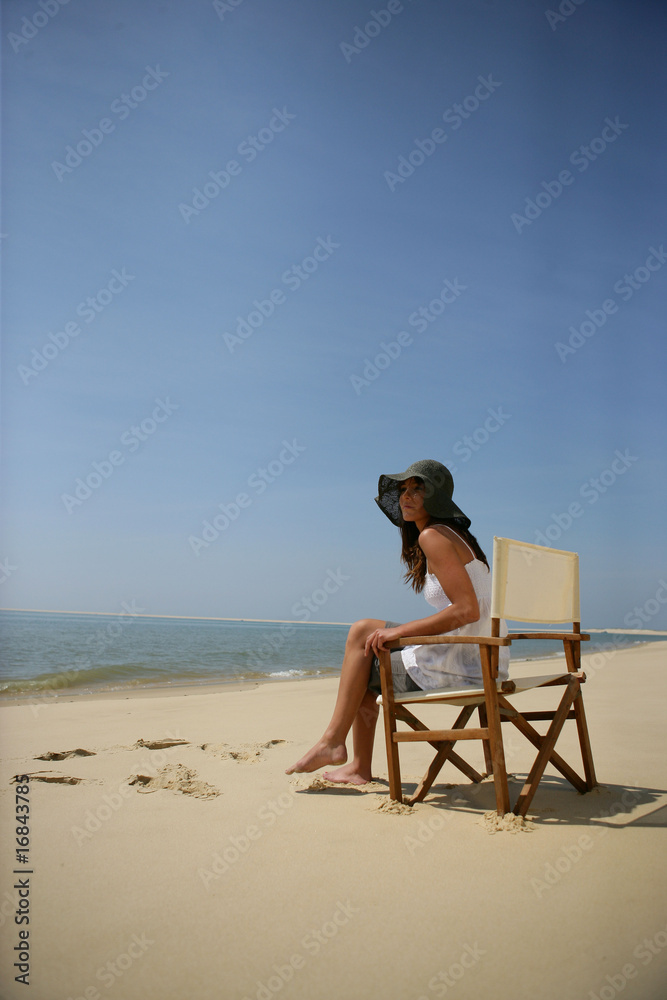 Femme assise sur une chaise au bord de la mer