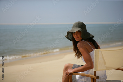 Portrait d'une femme assise sur une chaise au bord de la mer