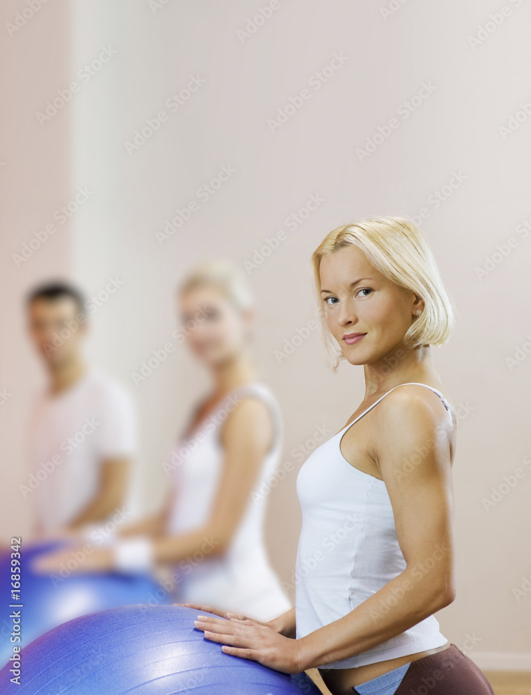 Group of people doing fitness exercise with a ball.. Group of people doing fitness exercise with a ball..