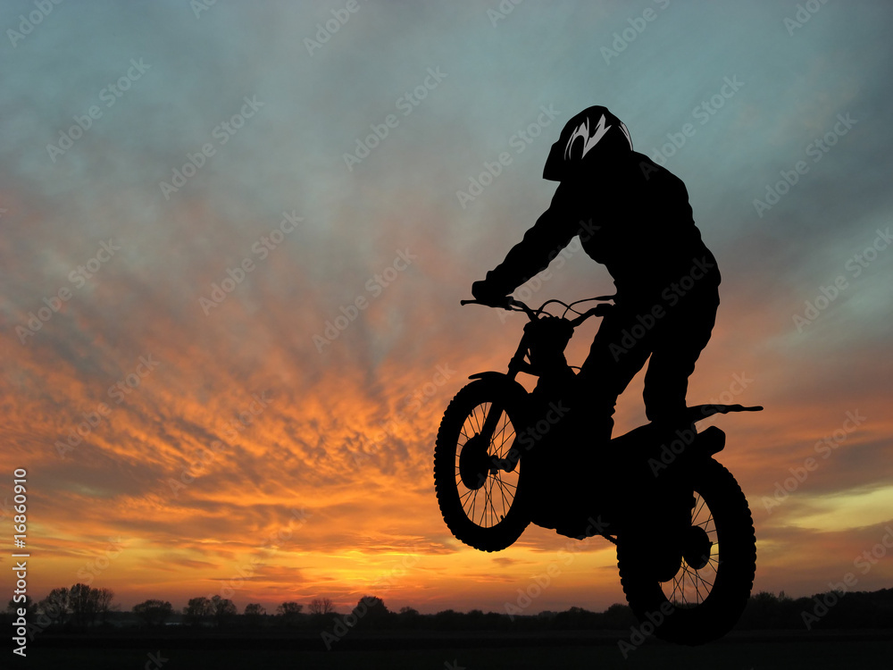 Naklejka premium Motorcyclist in sunset