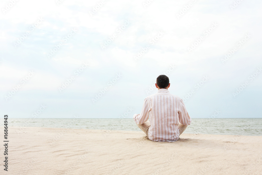young man meditating at the seaside