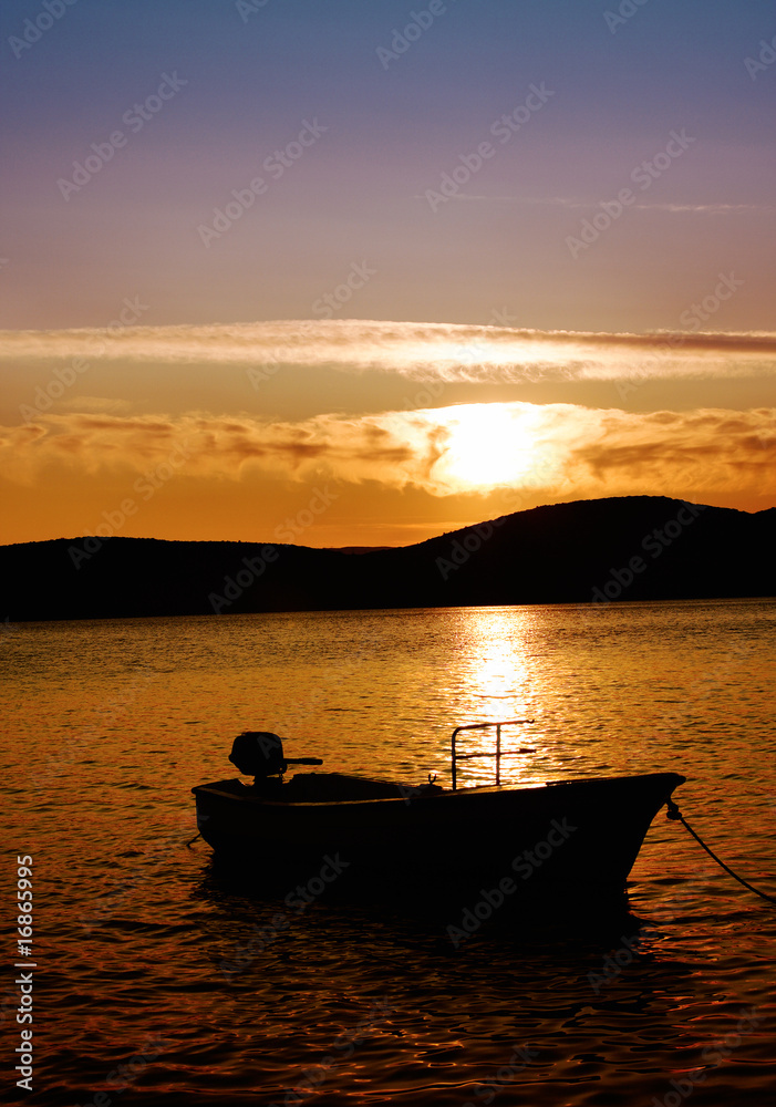 lonely boat at sunset over adriatic sea