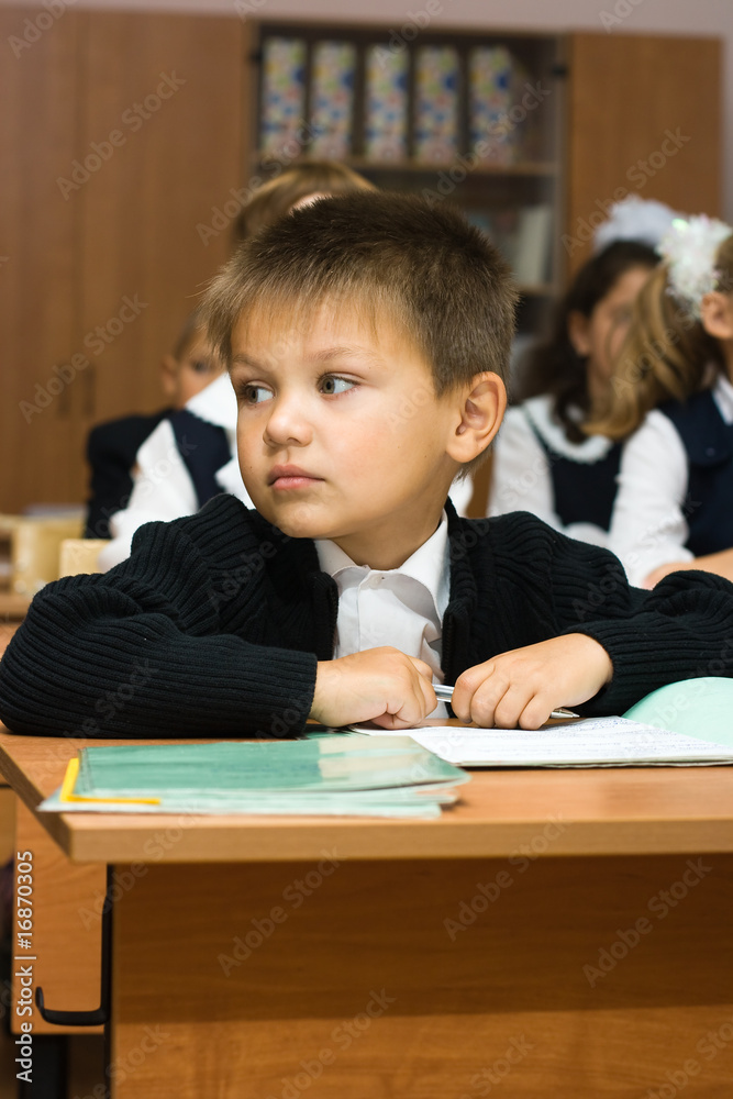 The boy at school at a lesson looks aside The boy at school at a lesson looks aside