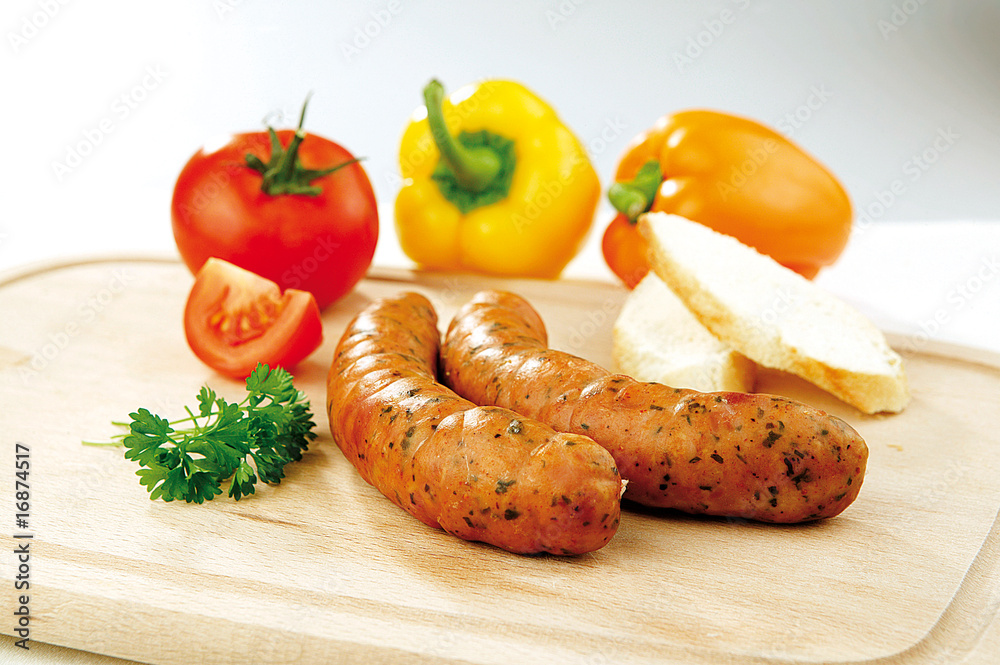 Two sausages and vegetable on a wooden board Two sausages and vegetable on a wooden board