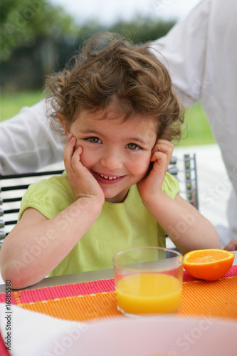 Portrait d'une petite fille souriante assise à table