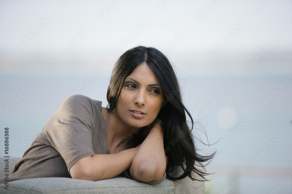 Portrait d'une belle femme pensive assise sur un canapé Portrait d'une belle femme pensive assise sur un canapé