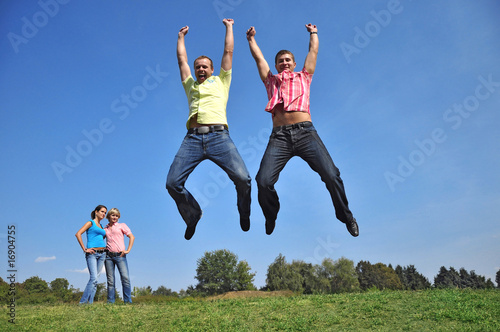 Two guys are jumping with their hands up