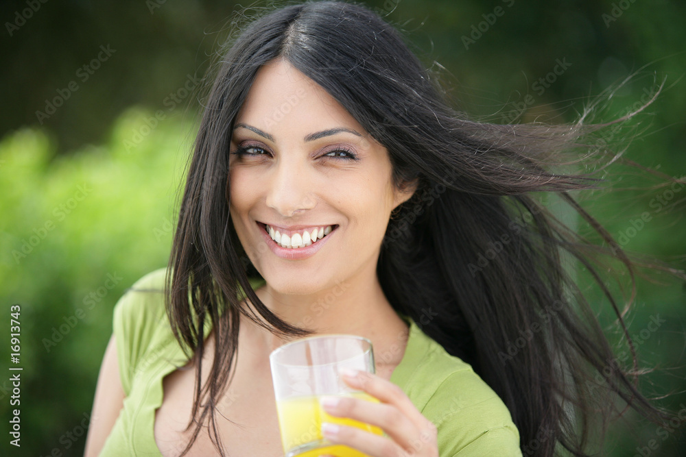 femme souriante avec un verre de jus d'orange à la main femme souriante avec un verre de jus d'orange à la main