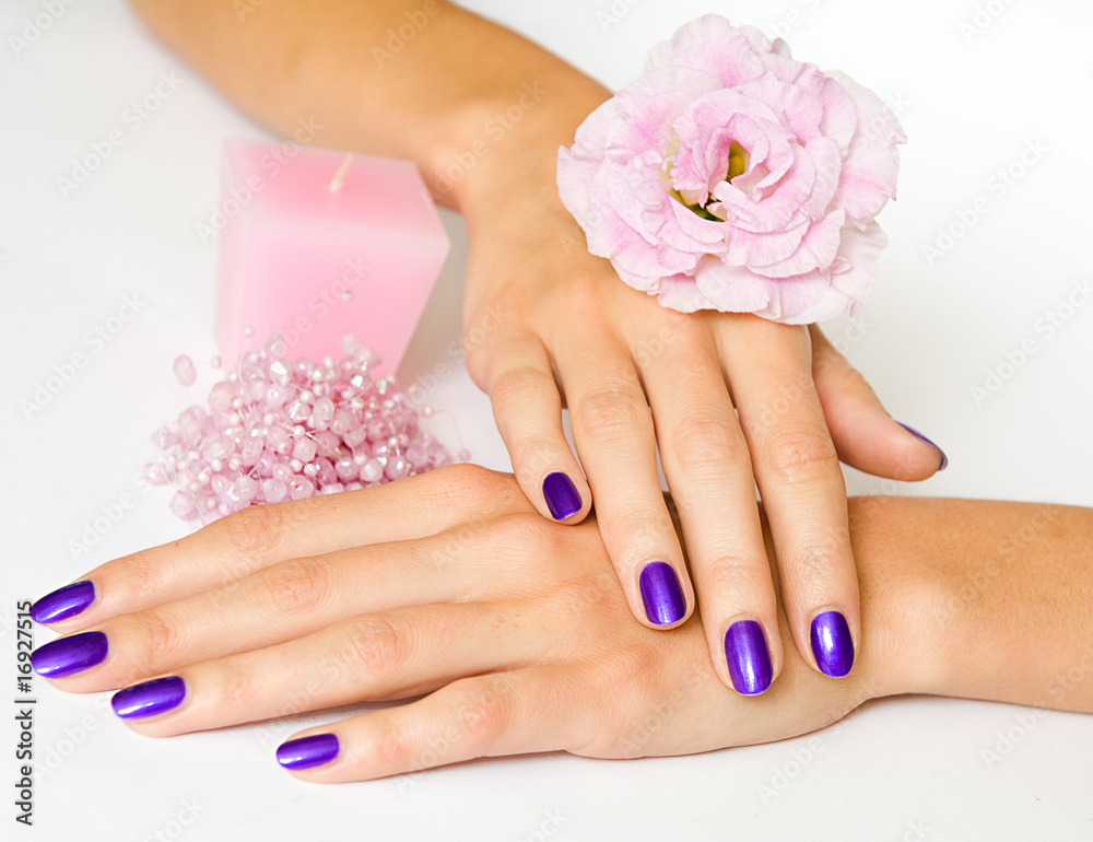 Fototapeta premium Woman hands with manicure, pink candle, flower and beads