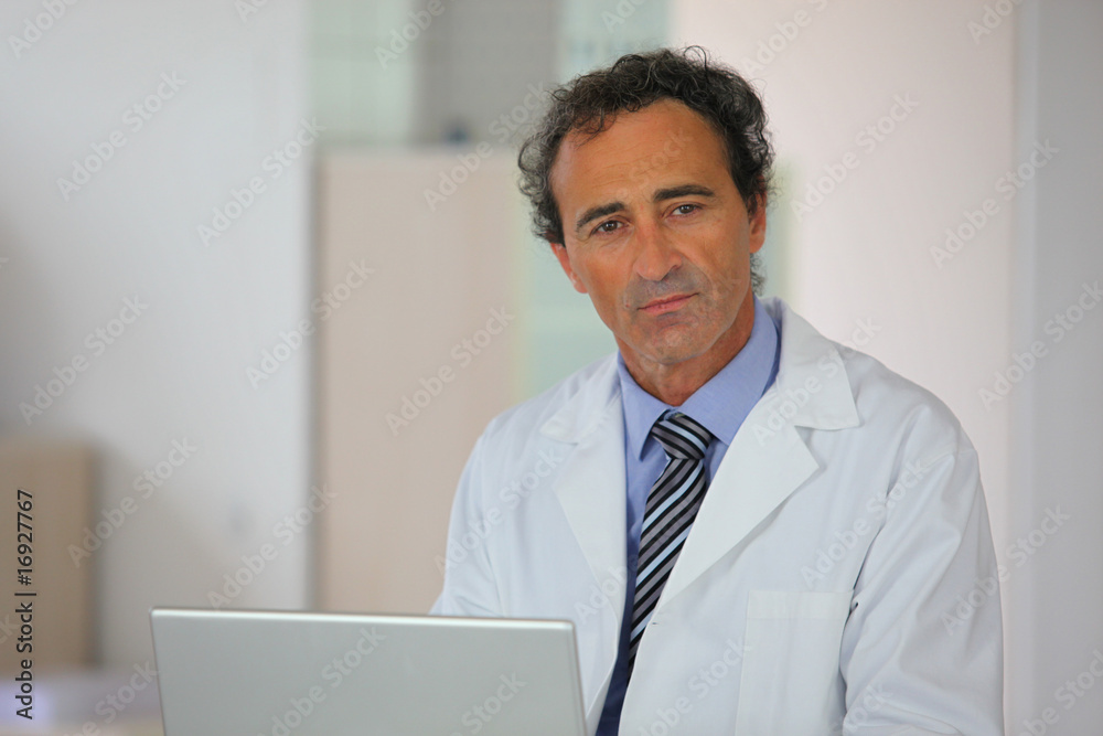 homme en blouse blanche devant un ordinateur portable homme en blouse blanche devant un ordinateur portable