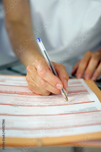 Femme écrivant sur un document médicale photo