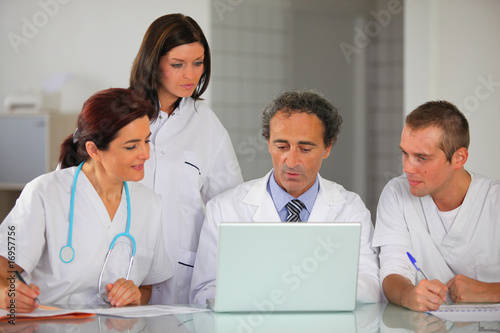 hommes et femmes en blouse blanche devant un ordinateur
