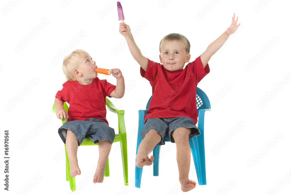 Two boys with popsicles on lawn chairs Two boys with popsicles on lawn chairs