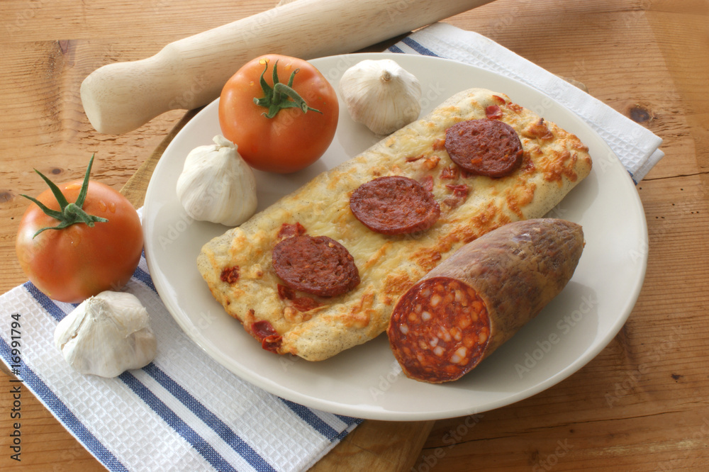 stone oven backed salami pizza, tomato and garlic