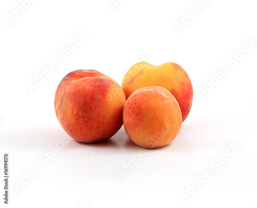 Arrangement of three ripe peaches