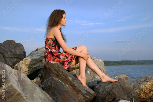 Beautiful girl sit on rock on sea coast © mr.markin
