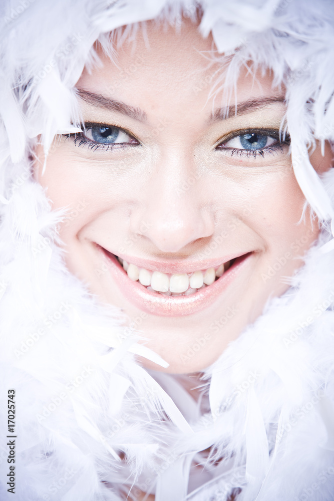 portrait of smiling young woman with white downy boa