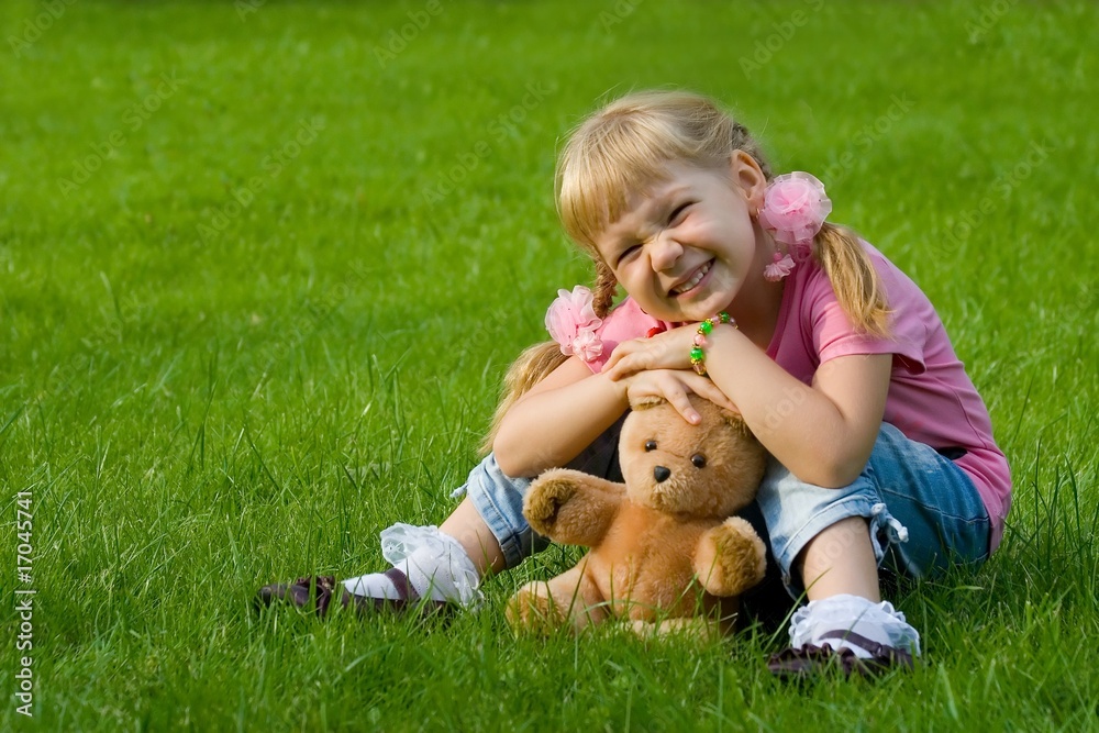 Cute little girl in grass with teddy bear. Cute little girl in grass with teddy bear.