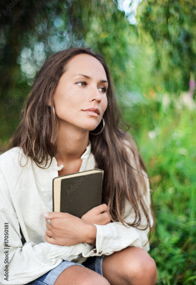 Thoughtful Young lady embracing the book in the hands Thoughtful Young lady embracing the book in the hands