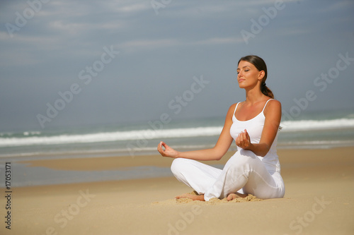 femme m  ditant en fermant les yeux assise au bord de la mer